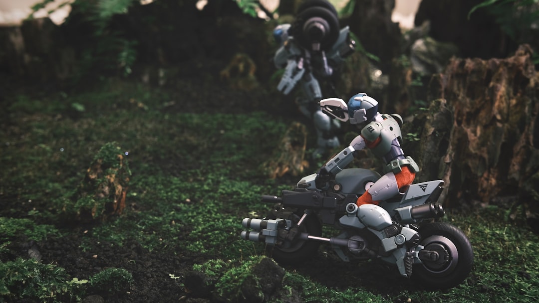a couple of toy motorcycles sitting on top of a lush green field